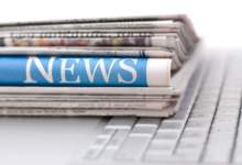 Newspapers sitting on a keyboard.