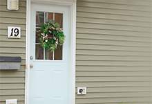 A photo of a white door with a window. It is the front door of a home with mailbox and the number 19.